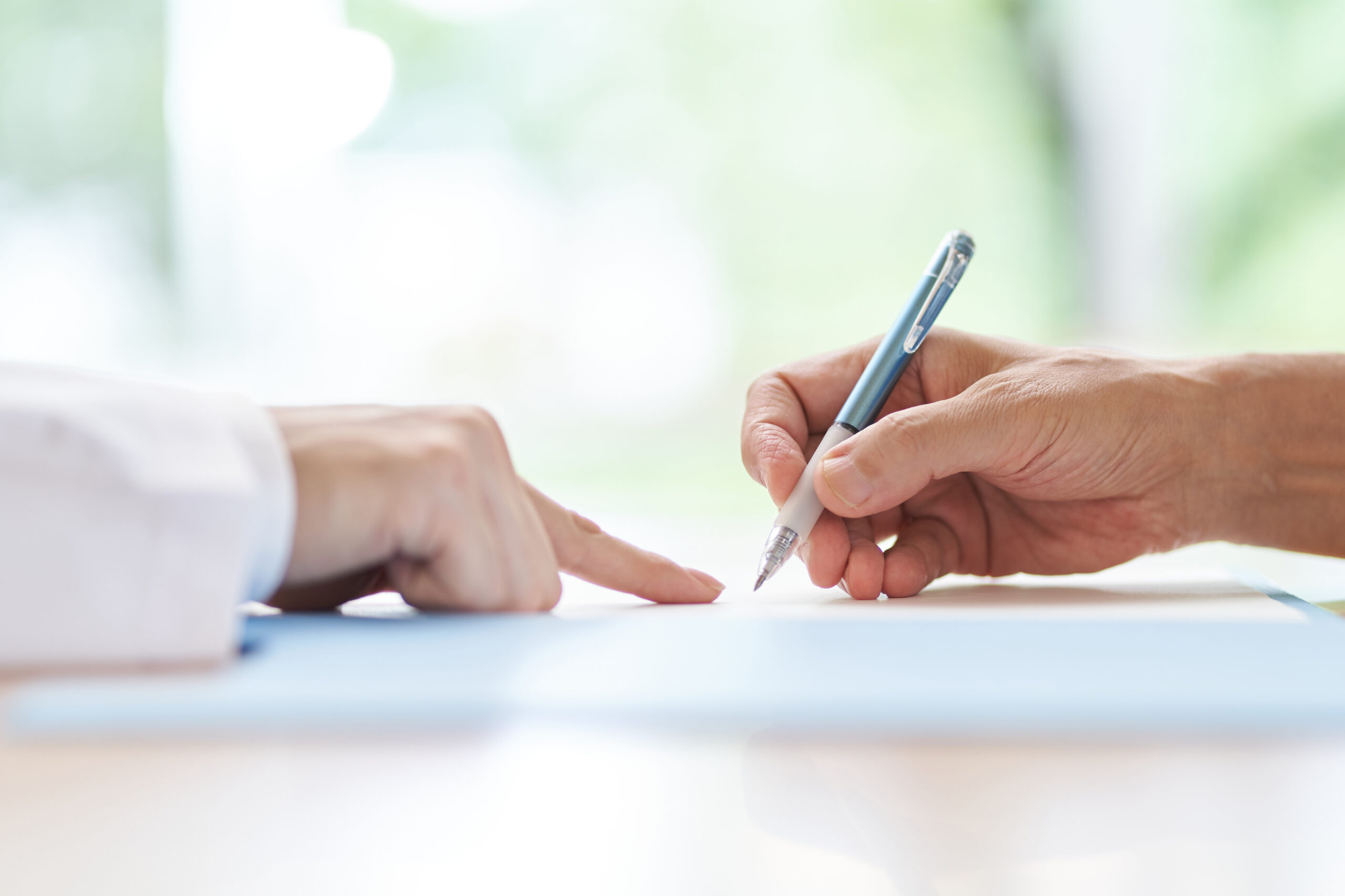 Elderly people signing with a doctor explaining the contract